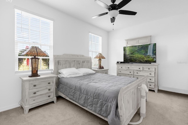 bedroom featuring baseboards, a ceiling fan, and light colored carpet