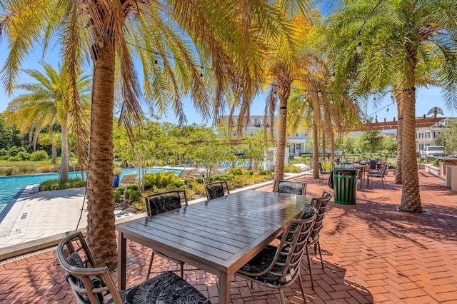 view of patio / terrace featuring a water view, an outdoor pool, and outdoor dining space