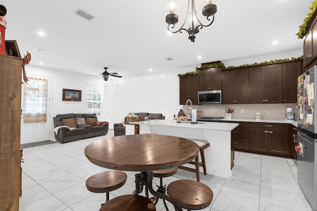 kitchen featuring visible vents, appliances with stainless steel finishes, open floor plan, marble finish floor, and light countertops