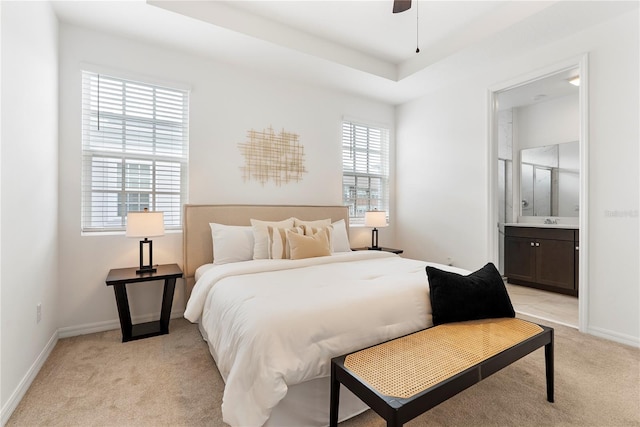 2097 Celebration Blvd, Celebration, FL 34747 - bedroom featuring light colored carpet, connected bathroom, and a raised ceiling