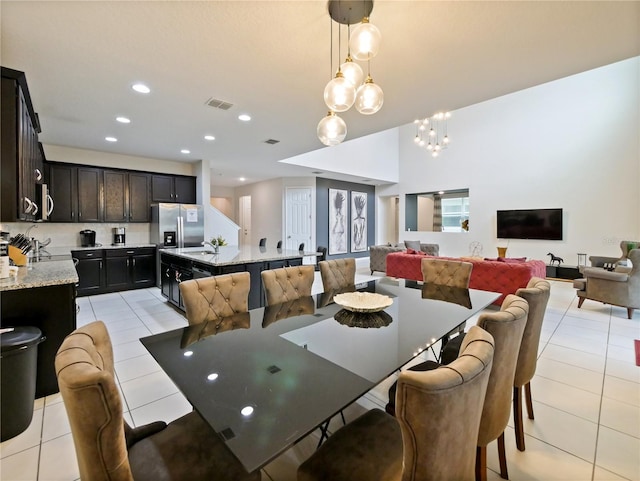 dining space featuring a notable chandelier, light tile patterned flooring, and sink