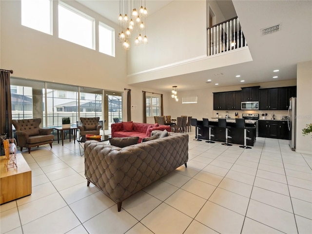 tiled living room with a towering ceiling and an inviting chandelier