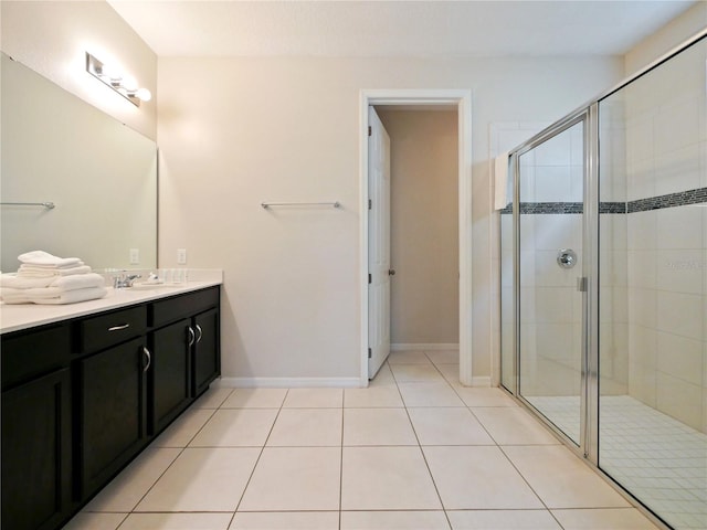 bathroom with tile patterned flooring, vanity, and a shower with door