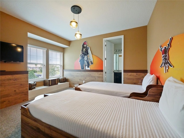 carpeted bedroom featuring wood walls