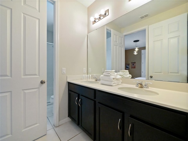 bathroom with tile patterned flooring, vanity, and toilet