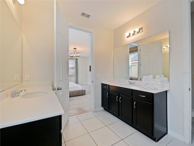 bathroom with tile patterned floors, vanity, and a notable chandelier