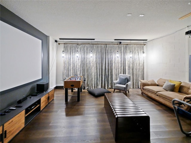 cinema room with a textured ceiling and dark hardwood / wood-style floors