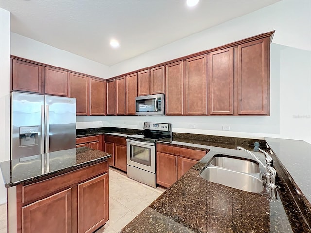 kitchen featuring light tile patterned floors, recessed lighting, stainless steel appliances, a sink, and dark stone counters