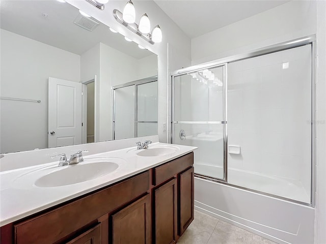 full bath with double vanity, enclosed tub / shower combo, a sink, and tile patterned floors