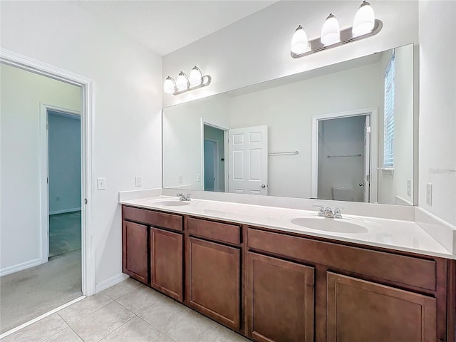 full bath with double vanity, a sink, toilet, and tile patterned floors