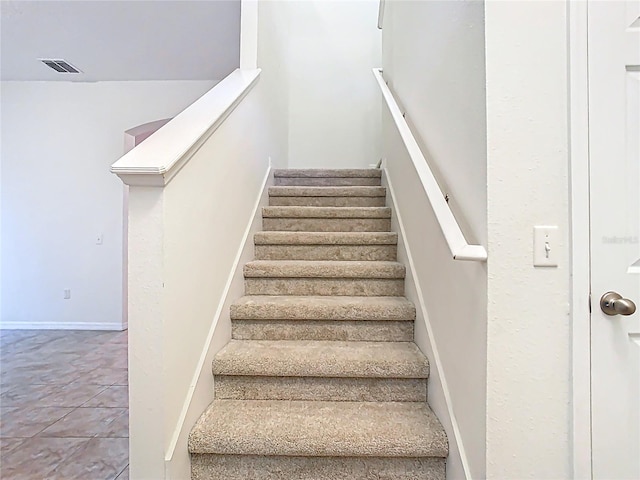 staircase featuring visible vents and tile patterned floors