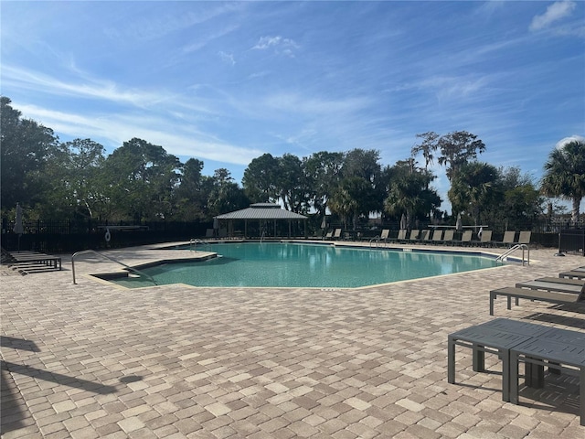 community pool with fence and a patio