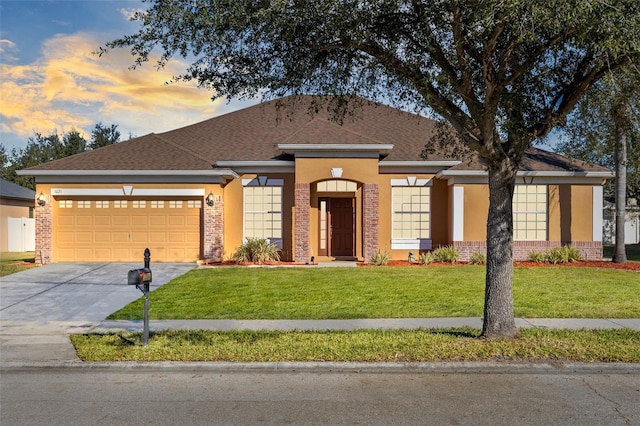 single story home with a garage and a lawn