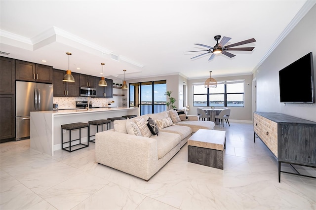 living room featuring ceiling fan and crown molding