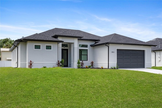 prairie-style house featuring a garage and a front lawn