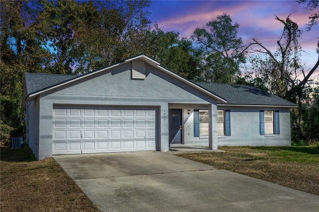 ranch-style home with central air condition unit, a lawn, and a garage