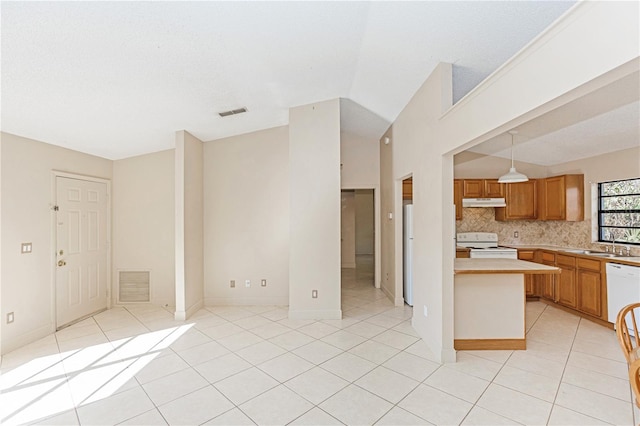 kitchen featuring pendant lighting, white appliances, sink, decorative backsplash, and light tile patterned floors