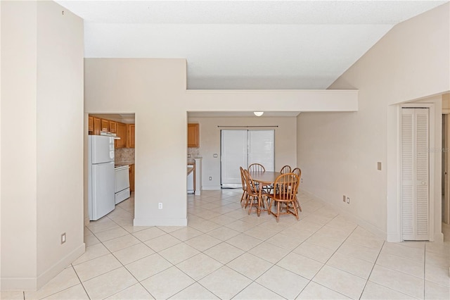 tiled dining area with high vaulted ceiling