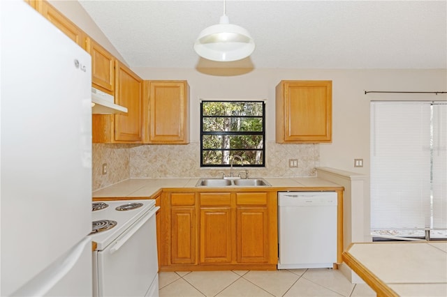 kitchen with pendant lighting, white appliances, and tile countertops