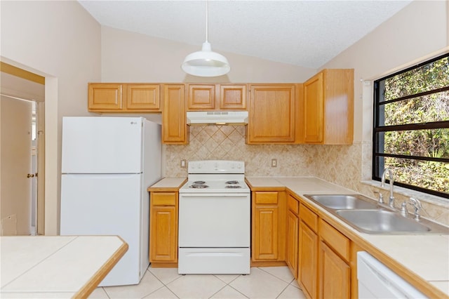 kitchen featuring white appliances, sink, hanging light fixtures, vaulted ceiling, and light tile patterned flooring