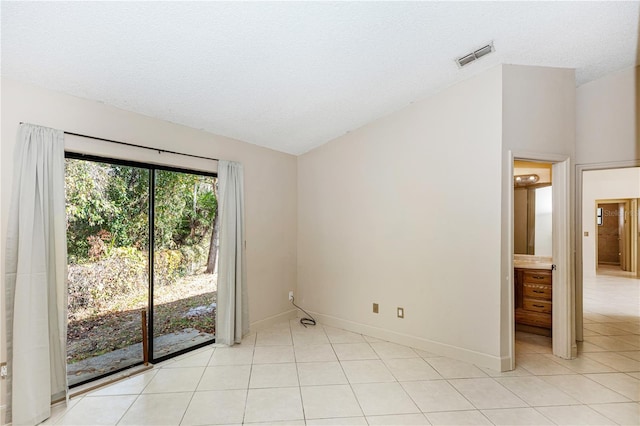 empty room with light tile patterned floors and a textured ceiling