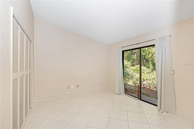1073 Humphrey Blvd, Deltona, FL 32738 - unfurnished bedroom with baseboards, access to outside, light tile patterned floors, lofted ceiling, and a textured ceiling