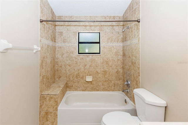 bathroom with toilet and tiled shower / bath