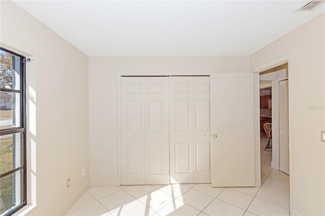 1073 Humphrey Blvd, Deltona, FL 32738 - unfurnished bedroom with light tile patterned flooring, a closet, and a textured ceiling