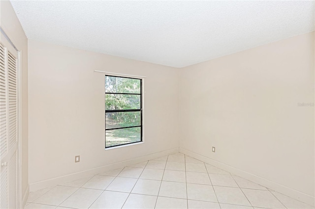 tiled spare room with a textured ceiling