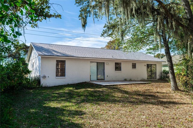 1073 Humphrey Blvd, Deltona, FL 32738 - back of house featuring stucco siding, a yard, a patio area, and a shingled roof