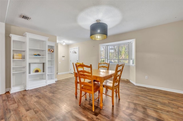 dining area with hardwood / wood-style floors and a textured ceiling