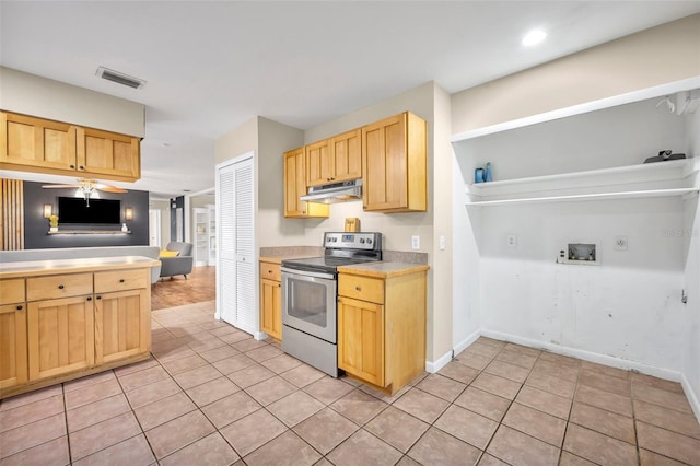 kitchen featuring stainless steel electric range oven, light brown cabinets, and light tile patterned floors