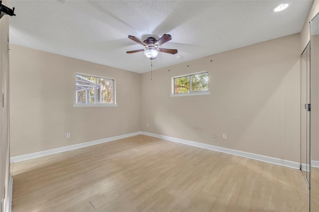 unfurnished room featuring ceiling fan, light hardwood / wood-style floors, and a textured ceiling