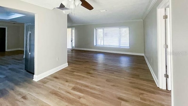 unfurnished room with hardwood / wood-style flooring, ceiling fan, and ornamental molding