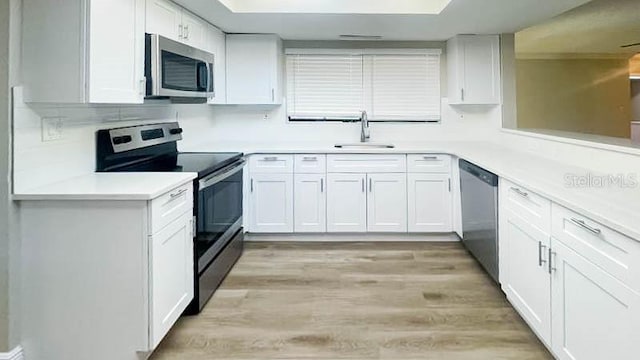 kitchen featuring stainless steel appliances, sink, and white cabinets