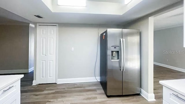 kitchen featuring stainless steel refrigerator with ice dispenser, white cabinetry, and light hardwood / wood-style floors