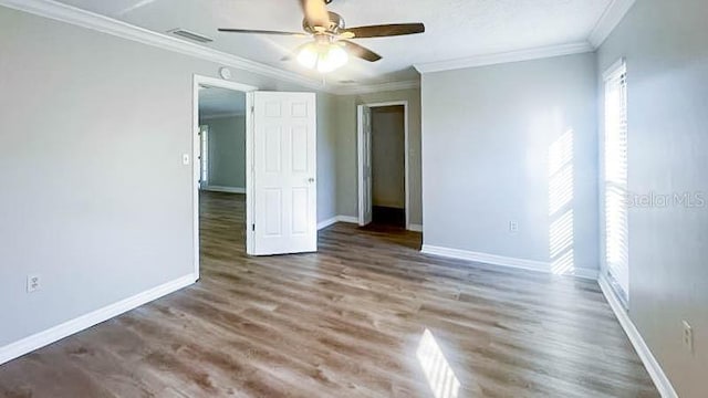 spare room with crown molding, wood-type flooring, and ceiling fan