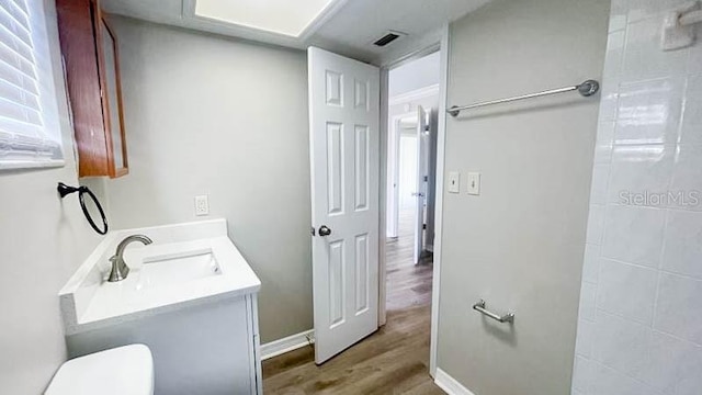 bathroom with vanity, wood-type flooring, and toilet