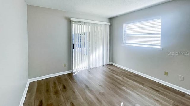 spare room with dark hardwood / wood-style flooring and a textured ceiling