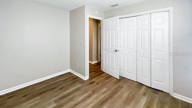 unfurnished bedroom with hardwood / wood-style flooring and a closet