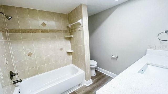 full bathroom featuring hardwood / wood-style flooring, vanity, toilet, and tiled shower / bath combo