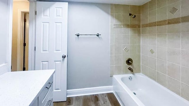 bathroom with vanity, hardwood / wood-style floors, and tiled shower / bath