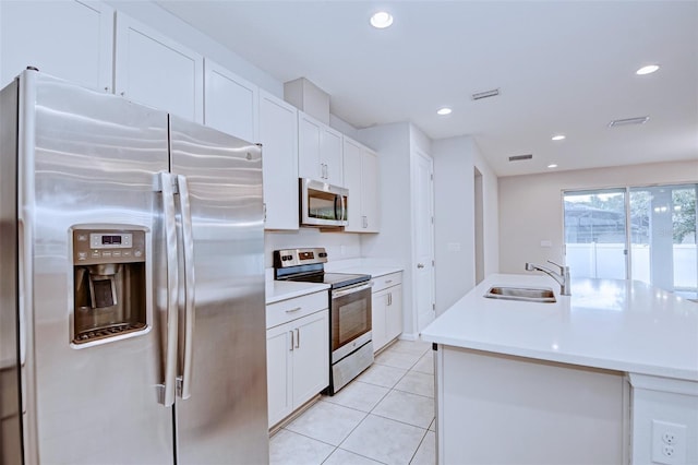 kitchen with white cabinets, appliances with stainless steel finishes, an island with sink, and sink