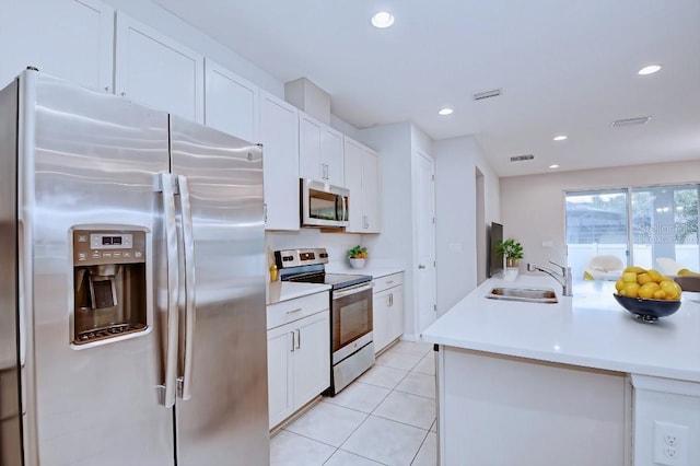 kitchen with sink, white cabinets, light tile patterned flooring, and appliances with stainless steel finishes