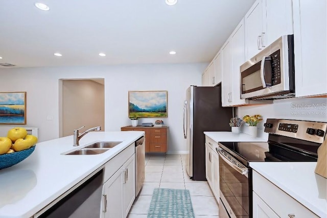 kitchen with sink, white cabinets, light tile patterned floors, and appliances with stainless steel finishes