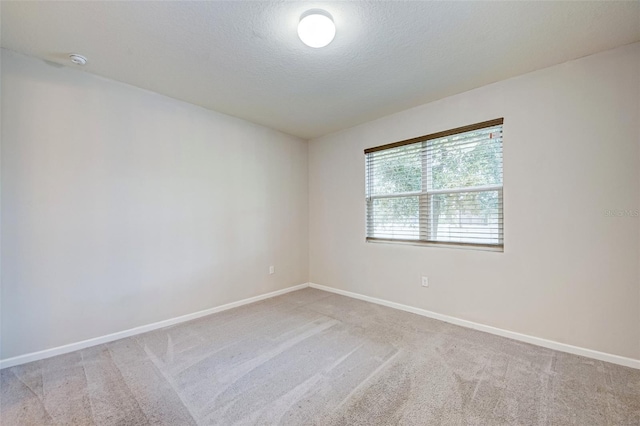 carpeted spare room featuring a textured ceiling