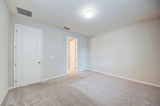 carpeted spare room with a textured ceiling