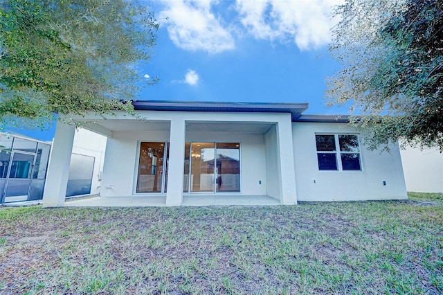 rear view of house featuring a patio and a lawn