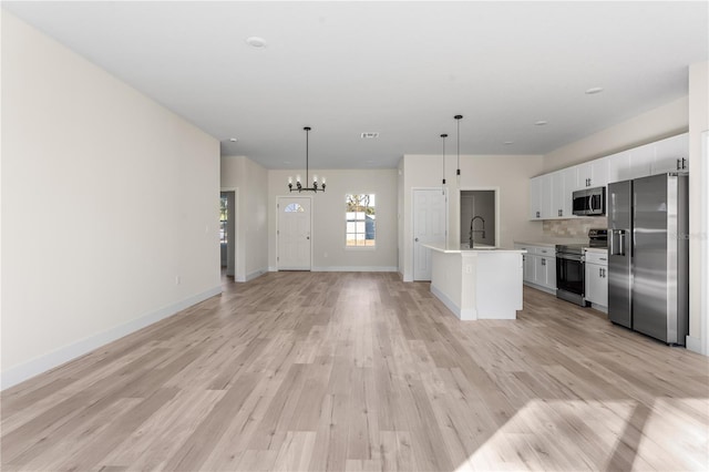 kitchen with sink, an island with sink, light hardwood / wood-style floors, white cabinetry, and stainless steel appliances