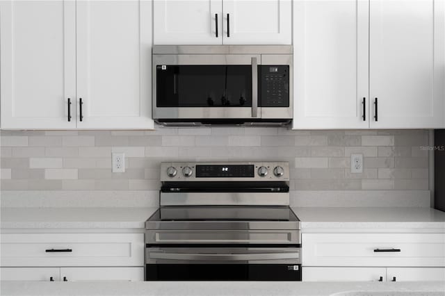 kitchen featuring white cabinets, appliances with stainless steel finishes, and tasteful backsplash